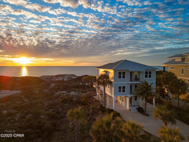 view of front of home with a balcony and a water view