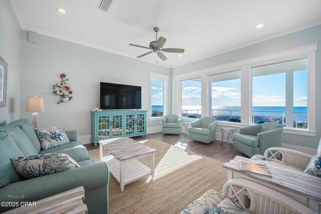 living room featuring ceiling fan, a healthy amount of sunlight, wood-type flooring, and crown molding