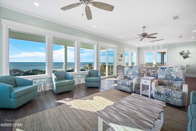 living room with a water view, ceiling fan, dark hardwood / wood-style floors, and ornamental molding