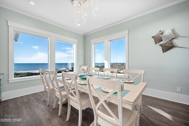 dining area with dark wood-type flooring, a chandelier, a water view, and plenty of natural light