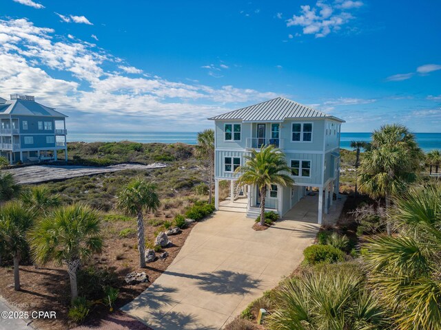 beach home with a water view, a balcony, and a carport