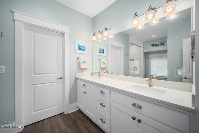 bathroom featuring a shower with shower door, hardwood / wood-style floors, and vanity