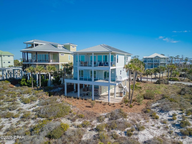 121 Gulf Hibiscus Dr, Port St Joe, FL 32456 - back of house with metal roof, a balcony, stairway, and a patio area