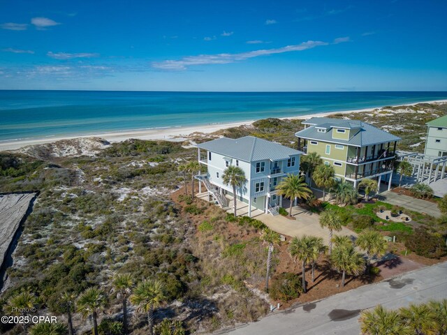 drone / aerial view featuring a water view and a beach view