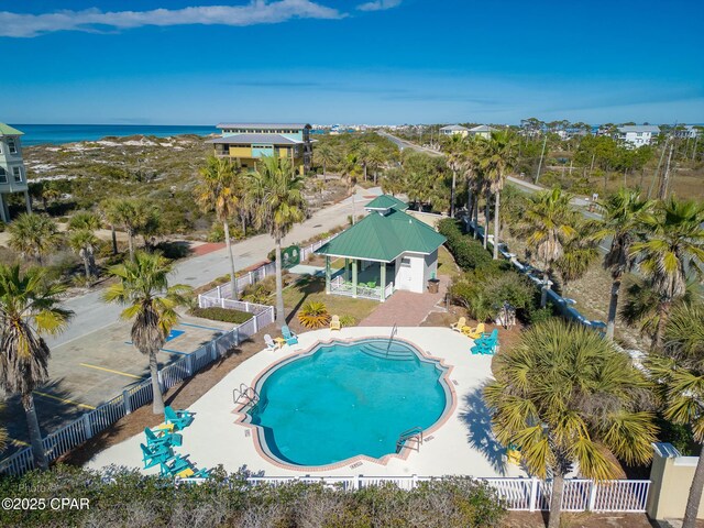 community pool featuring a patio, a water view, and a fenced backyard