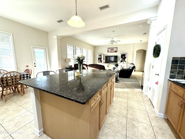 kitchen featuring pendant lighting, light tile patterned floors, dark stone counters, and a kitchen island