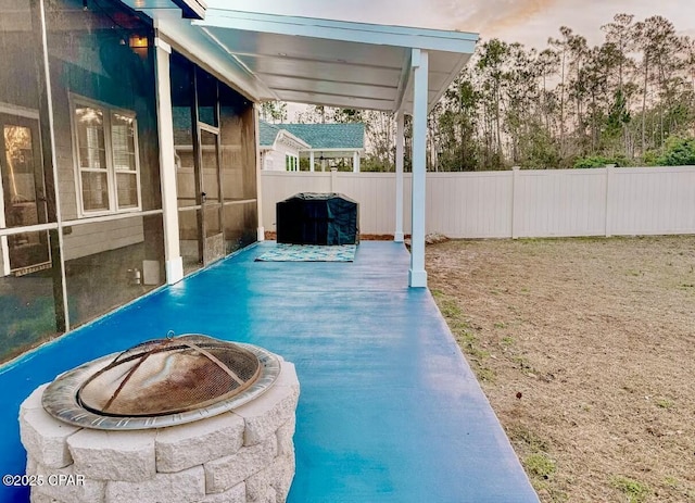 pool at dusk featuring a patio and a fire pit