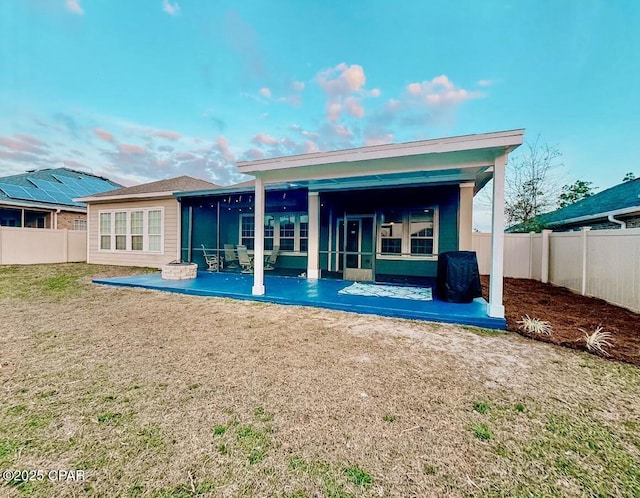 rear view of house with a yard, a sunroom, and a patio