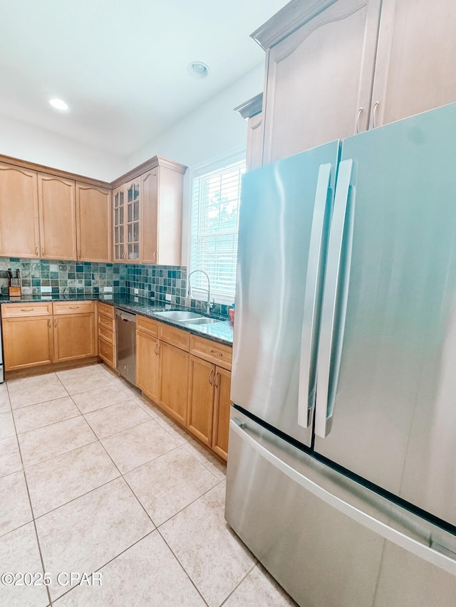 kitchen featuring sink, decorative backsplash, light tile patterned floors, stainless steel appliances, and light stone countertops