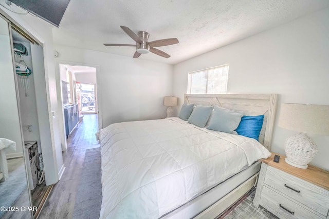 bedroom with ceiling fan, hardwood / wood-style floors, a closet, and a textured ceiling