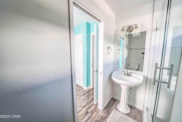 bathroom featuring hardwood / wood-style flooring, a textured ceiling, and toilet