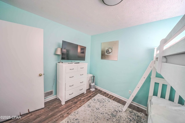 bedroom featuring dark wood-type flooring and a textured ceiling