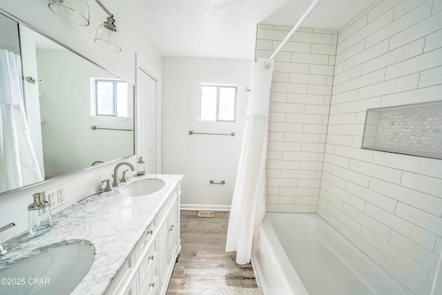 bathroom featuring hardwood / wood-style floors, vanity, a textured ceiling, and shower / bath combo