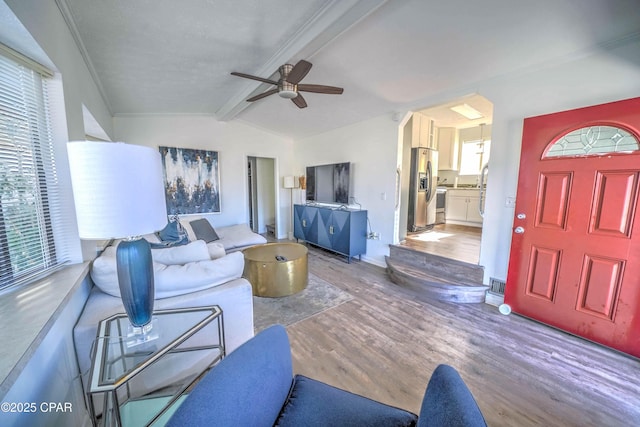 living room featuring ceiling fan, lofted ceiling with beams, and hardwood / wood-style floors