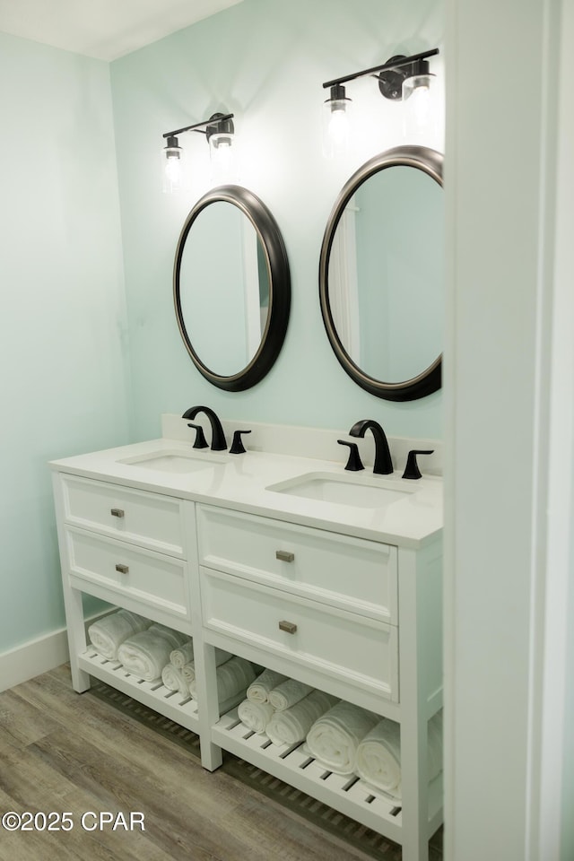 bathroom with double vanity, wood finished floors, and a sink