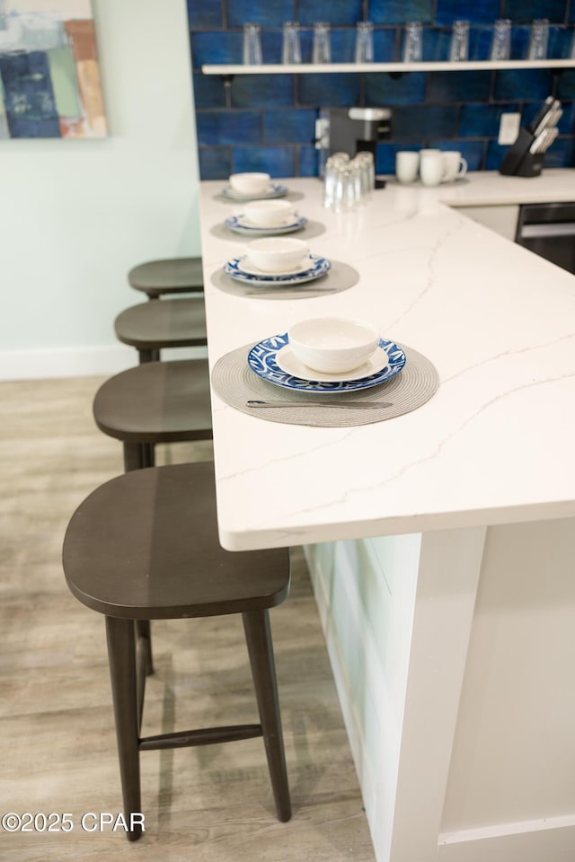 dining space with baseboards and wood finished floors
