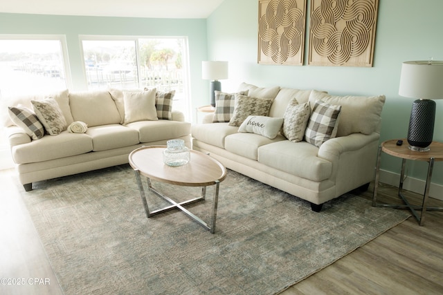 living room with baseboards, vaulted ceiling, and wood finished floors