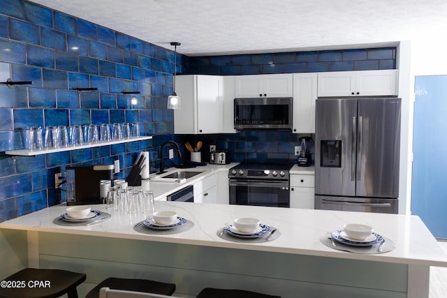 kitchen featuring a sink, decorative backsplash, white cabinets, and black appliances