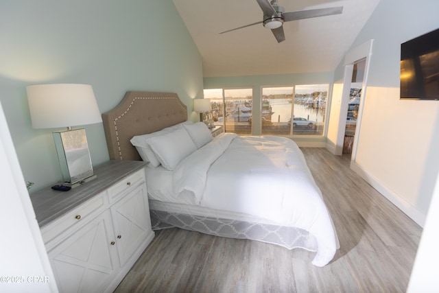 bedroom with baseboards, vaulted ceiling, light wood-style floors, and a ceiling fan