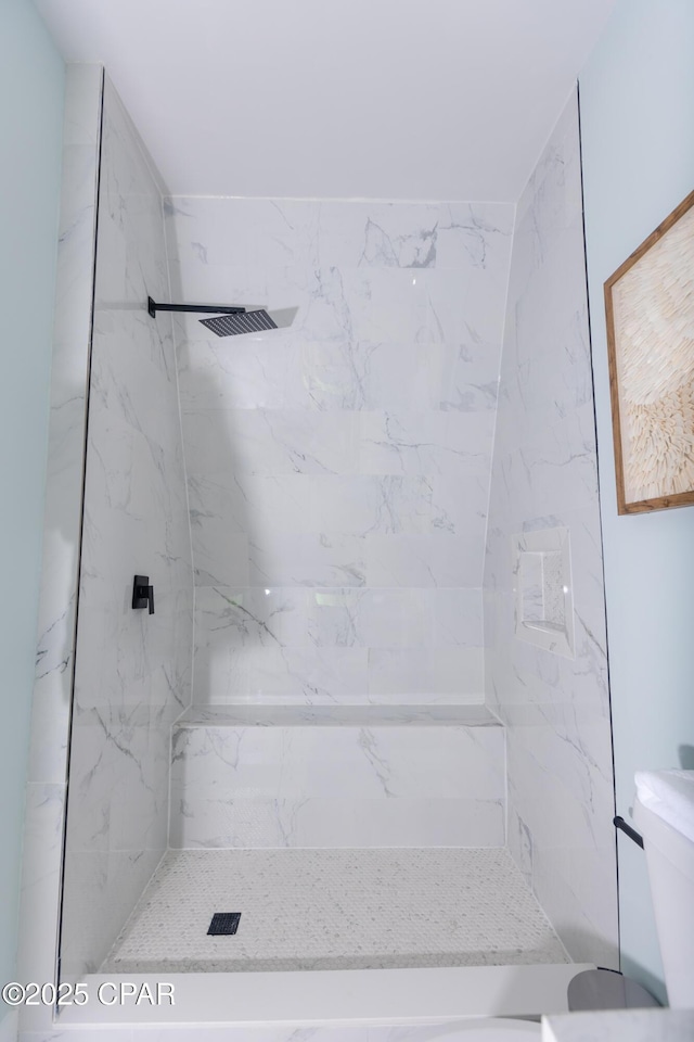 full bath featuring a marble finish shower and toilet