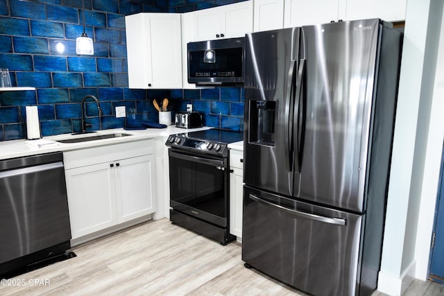kitchen with light countertops, a sink, white cabinetry, appliances with stainless steel finishes, and decorative backsplash