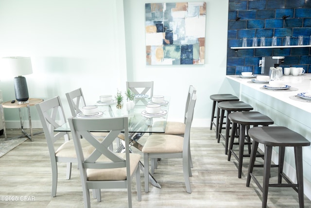 dining space featuring baseboards and wood finished floors