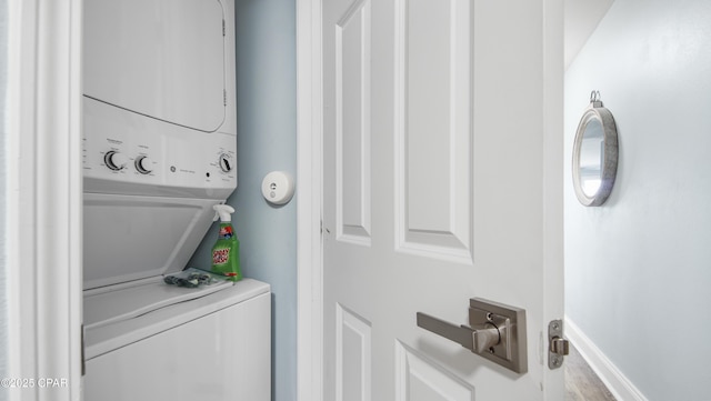 clothes washing area featuring stacked washer and clothes dryer