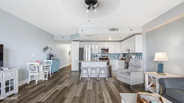 living room with ceiling fan, dark hardwood / wood-style floors, and sink