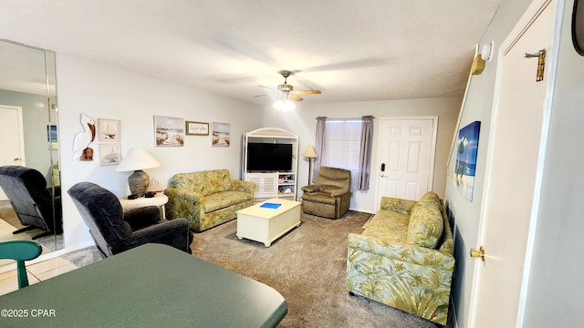 carpeted living area with a ceiling fan