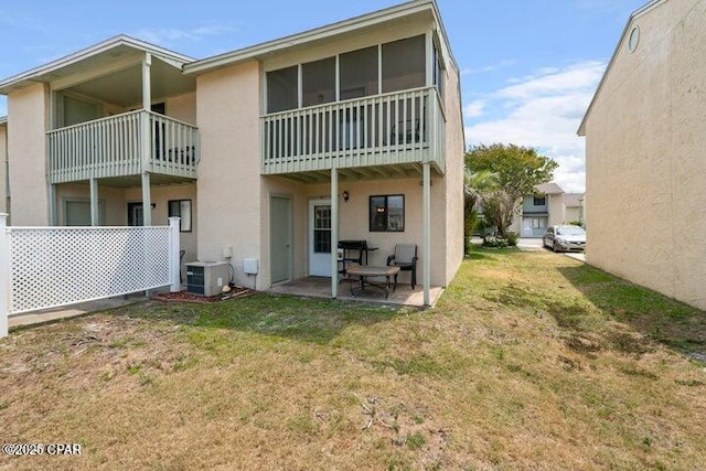 back of house featuring cooling unit, a patio area, a yard, and stucco siding