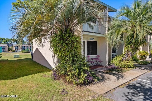 view of home's exterior with a lawn and stucco siding