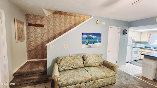 living room with a textured ceiling and baseboards