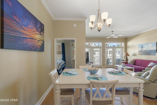 dining room featuring ceiling fan with notable chandelier, hardwood / wood-style floors, ornamental molding, and french doors