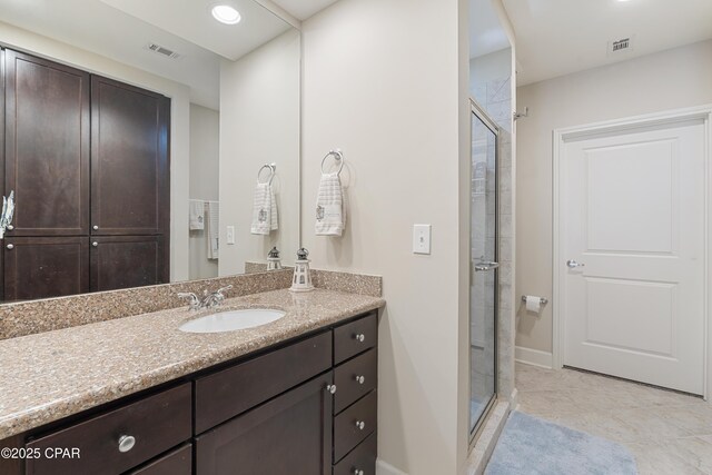 bathroom featuring walk in shower, vanity, and tile patterned flooring