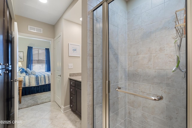 bathroom featuring a shower with shower door and vanity