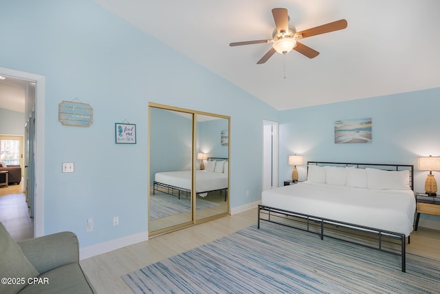 bedroom featuring ceiling fan, a closet, high vaulted ceiling, and light wood-type flooring