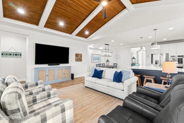 living room with ceiling fan with notable chandelier, lofted ceiling with beams, ornamental molding, wood ceiling, and light hardwood / wood-style floors