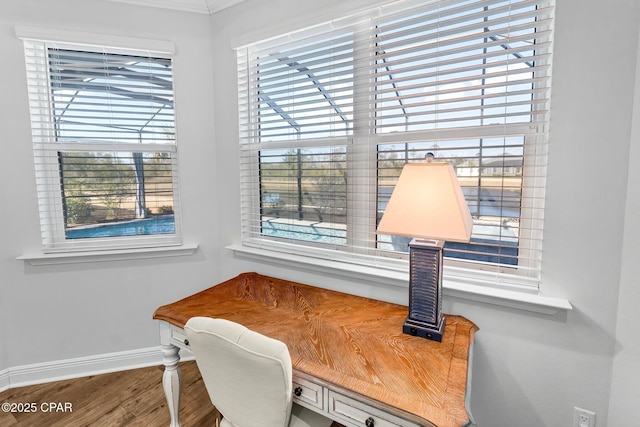 office area with wood finished floors, baseboards, and crown molding