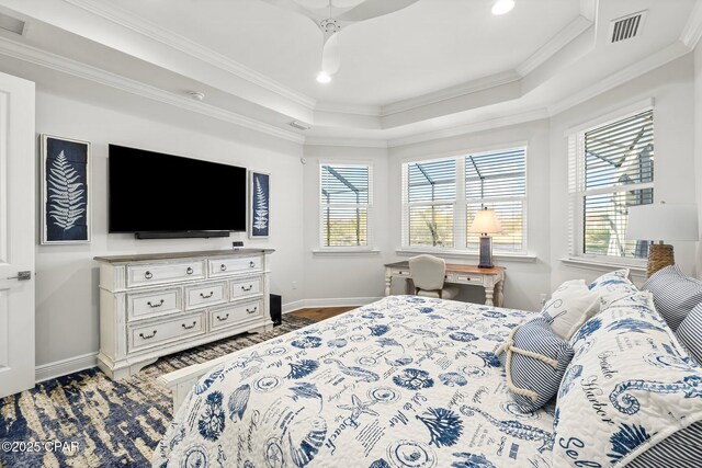 bedroom featuring a tray ceiling, visible vents, crown molding, and baseboards