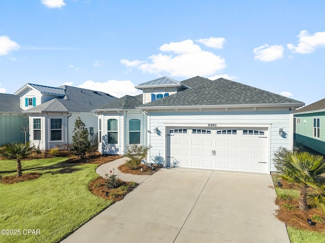 view of front facade with an attached garage, roof with shingles, a front yard, and concrete driveway