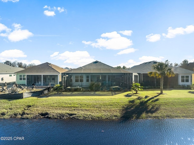 rear view of property with a water view and a yard