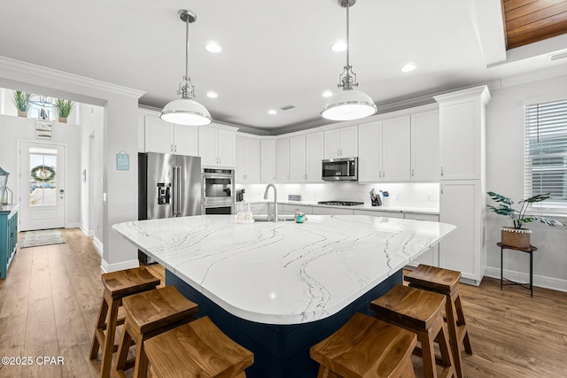 kitchen featuring white cabinetry, a spacious island, appliances with stainless steel finishes, and hanging light fixtures