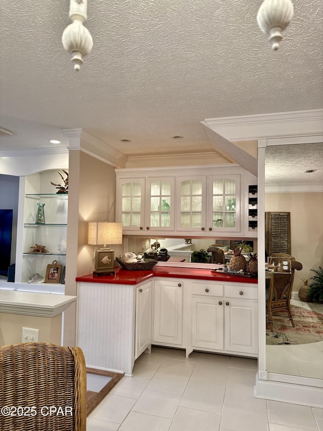 kitchen with ornamental molding, light tile patterned floors, and white cabinets