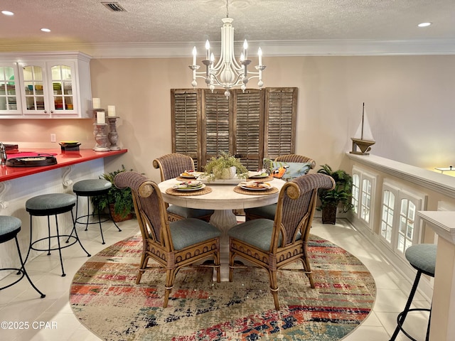 tiled dining area featuring crown molding, an inviting chandelier, and a textured ceiling