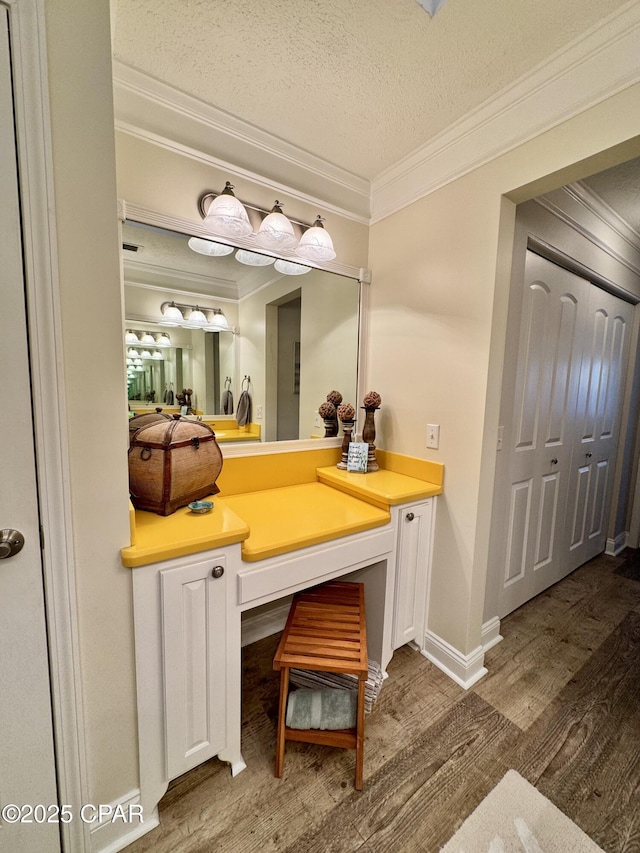 bathroom featuring ornamental molding, wood-type flooring, a textured ceiling, and vanity