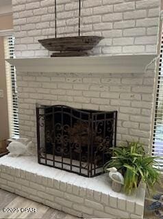 interior details with a brick fireplace and hardwood / wood-style flooring