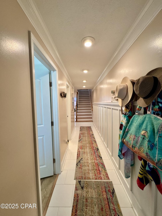 corridor with crown molding and light tile patterned floors