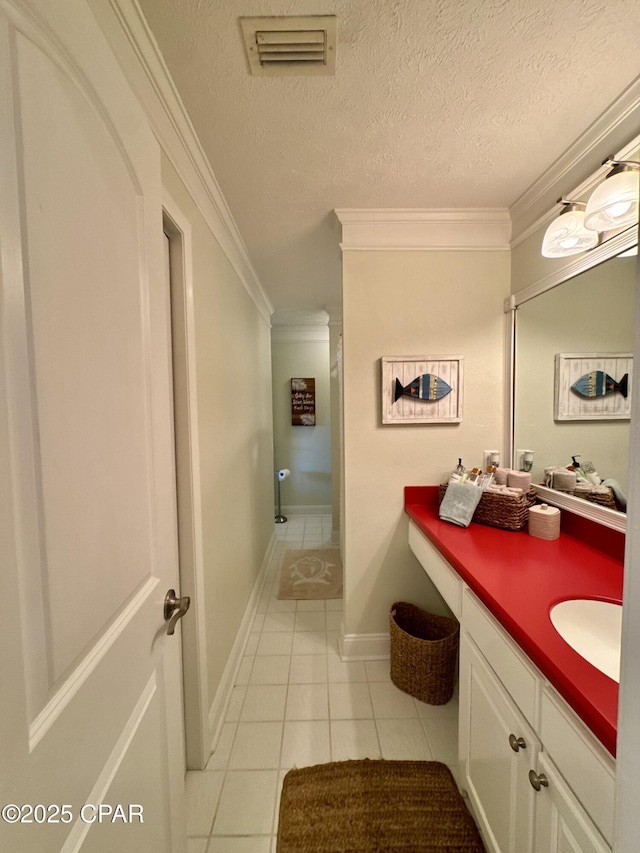 bathroom with tile patterned flooring, crown molding, vanity, and a textured ceiling