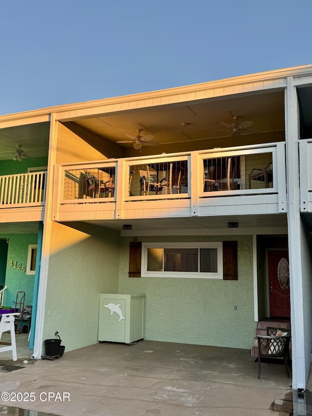 back of house with ceiling fan, a patio, and a balcony