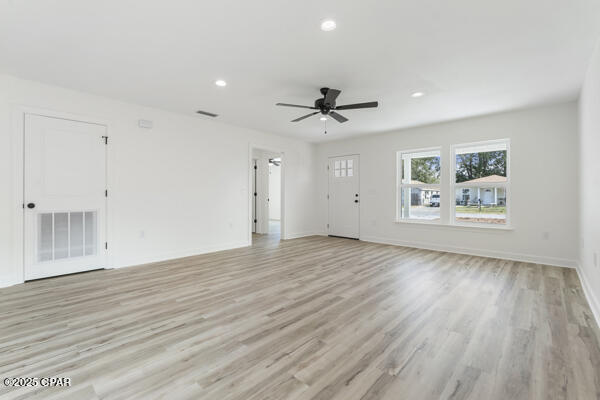 kitchen featuring light hardwood / wood-style floors, dark stone counters, white cabinets, and appliances with stainless steel finishes